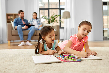 Image showing happy sisters drawing in sketchbooks at home