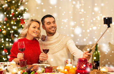 Image showing couple taking picture by selfie stick at christmas