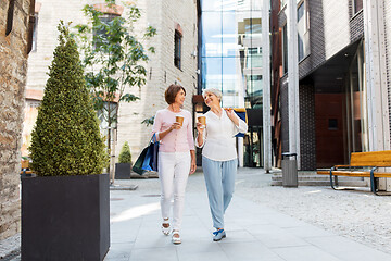 Image showing senior women with shopping bags and coffee in city