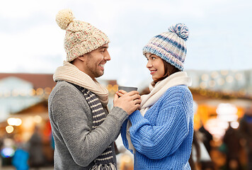 Image showing happy couple holding one cup at christmas market