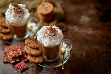 Image showing Two tall glasses with hot chocolate, whipped cream and cinnamon powder on top