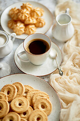 Image showing Side view of delicious dessert served. Butter and coconut cookies with cup of black coffee