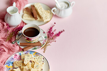 Image showing Hot chocolate or cocoa in cup with various sweets on sides. White chocolate bar and biscuits