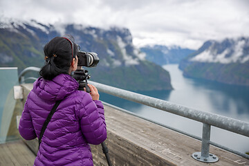 Image showing Nature photographer tourist with camera shoots. Stegastein Looko