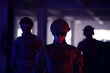 Image showing soldier squad team walking in urban environment colored lightis