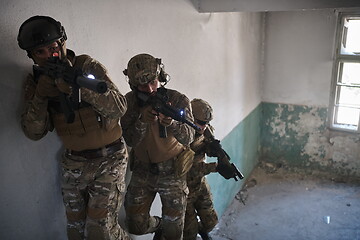 Image showing modern warfare soldiers ascent stairs in combat