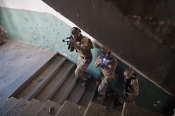 Image showing modern warfare soldiers ascent stairs in combat