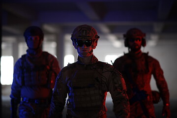 Image showing soldier squad team walking in urban environment colored lightis