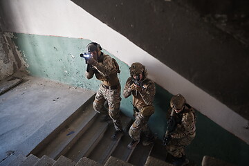 Image showing modern warfare soldiers ascent stairs in combat