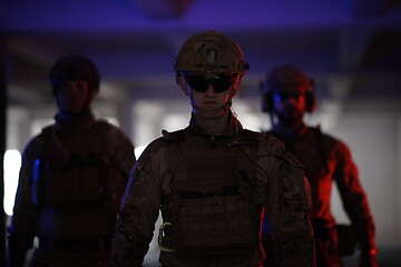 Image showing soldier squad team walking in urban environment colored lightis