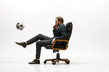 Image showing Businessman with football ball in office