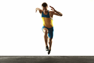 Image showing Young caucasian man running or jogging isolated on white studio background.