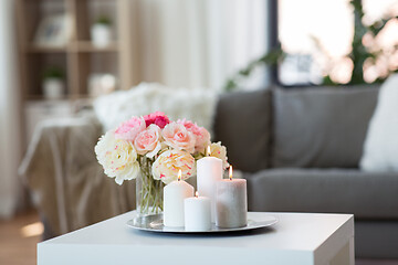 Image showing candles burning on table and flowers at cozy home