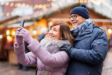 Image showing senior couple taking selfie at christmas market