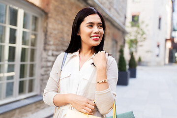 Image showing asian woman with shopping bags walking in city