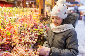 Image showing girl with lollipop at christmas market candy shop