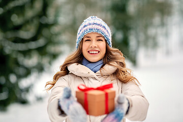 Image showing happy young woman with christmas gift in winter