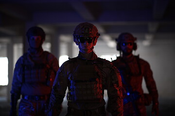 Image showing soldier squad team walking in urban environment colored lightis