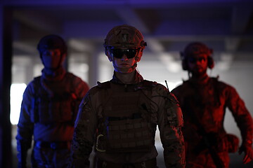 Image showing soldier squad team walking in urban environment colored lightis