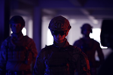 Image showing soldier squad team walking in urban environment colored lightis