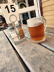 Image showing glass of beer outside on a wooden table