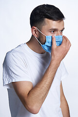 Image showing Young man wearing adjusting his medicine mask