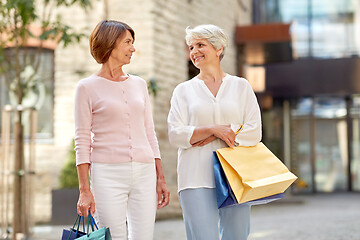 Image showing senior women with shopping bags walking in city