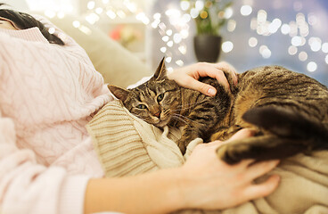 Image showing close up of owner with tabby cat in bed at home