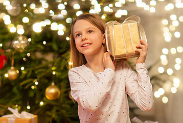 Image showing smiling girl with christmas gift at home