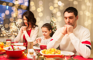 Image showing family praying before meal at christmas dinner