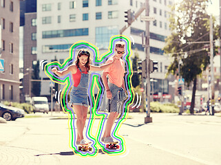 Image showing teenage couple riding skateboards on city street