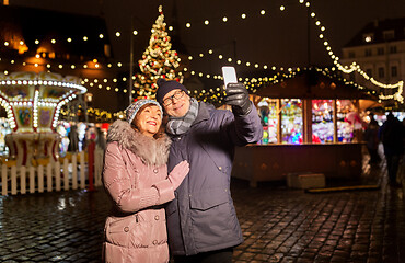 Image showing senior couple taking selfie at christmas market