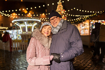 Image showing happy senior couple hugging at christmas market