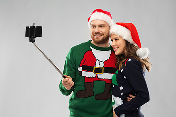 Image showing happy couple in christmas sweaters taking selfie
