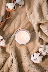 Image showing burning candle and cotton flower on blanket