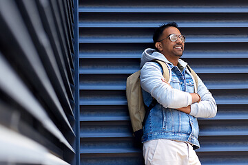 Image showing smiling indian man with backpack on city street