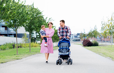 Image showing family with baby and stroller walking along city