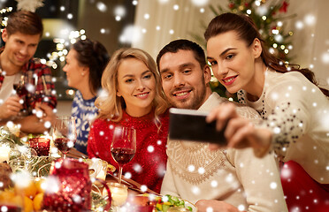 Image showing friends having christmas dinner and taking selfie