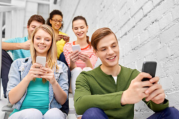 Image showing students with smartphones sitting on stairs