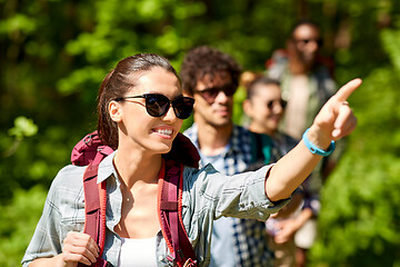 Image showing group of friends with backpacks hiking in forest