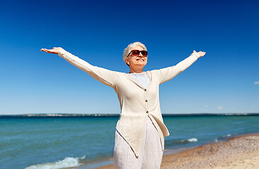 Image showing portrait of senior woman in sunglasses on beach