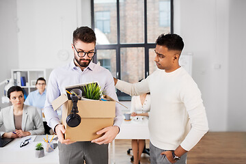 Image showing colleague seeing off sad fired male office worker