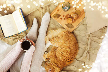 Image showing woman with coffee and red cat sleeping in bed