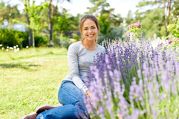 Image showing young woman and lavender flowers at summer garden