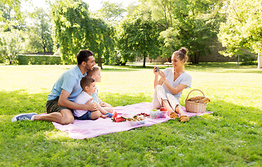 Image showing mother taking picture of family on picnic at park