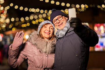 Image showing senior couple taking selfie at christmas market