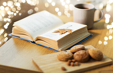 Image showing book with autumn leaf, cookies and tea on table