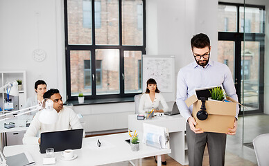 Image showing sad fired male office worker with personal stuff