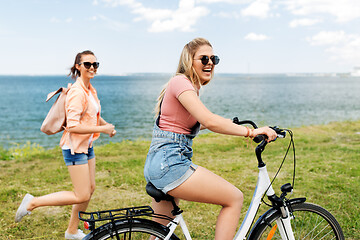 Image showing teenage girls or friends with bicycle in summer