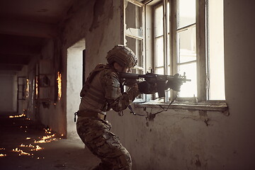 Image showing soldier in action near window changing magazine and take cover